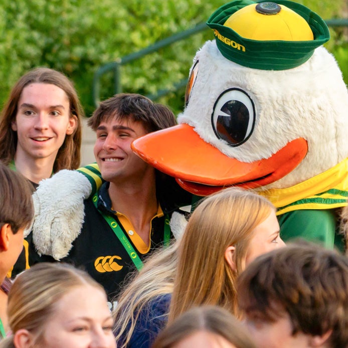A student receiving a hug from the UO Duck mascot