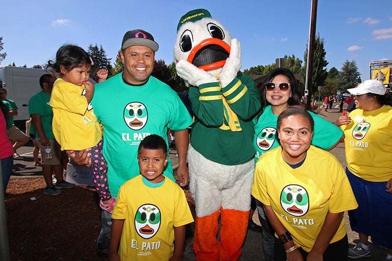 Volunteers and Students wearing "El Pato" t-shirts with The Duck at Fiesta Mexicana in Woodburn