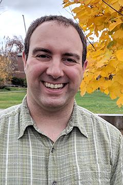 Profile photo of Alex Matiash wearing a green and white plaid button down shirt