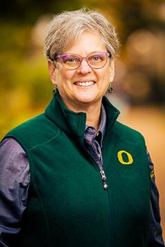 Profile photo of Sandra Gladney wearing a purple button-down shirt, and a UO-branded green vest